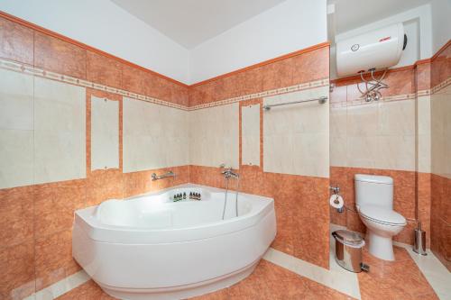 a bathroom with a large tub and a toilet at Villa Ritrovo in Sami