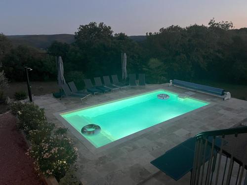 une grande piscine avec des chaises dans l'établissement La Tourelle du Lot, à Cajarc
