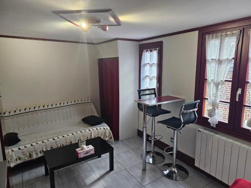 une chambre avec un lit, une table et des fenêtres dans l'établissement Petit Duplex, à Honfleur