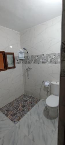 a bathroom with a toilet and a phone on the wall at Riad Ba Brahim in Rabat