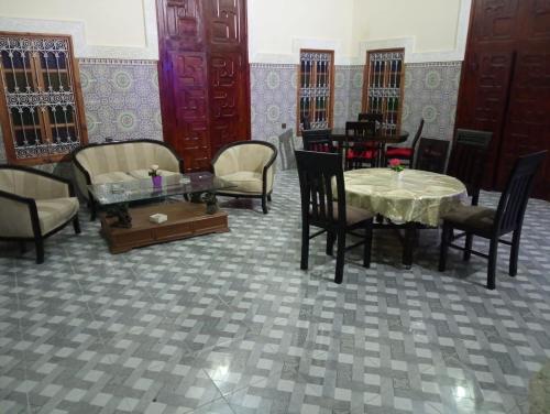 a dining room with chairs and a table and tables and chairs at Riad Ba Brahim in Rabat
