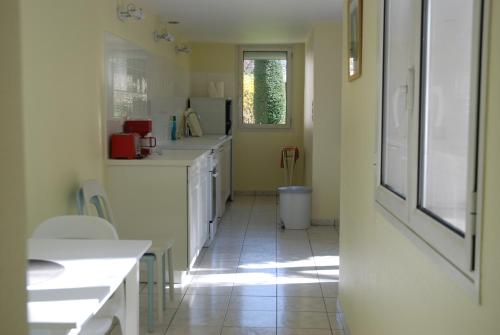 une cuisine avec des comptoirs blancs et une fenêtre dans l'établissement A l'abri du Ginkgo, à Tours