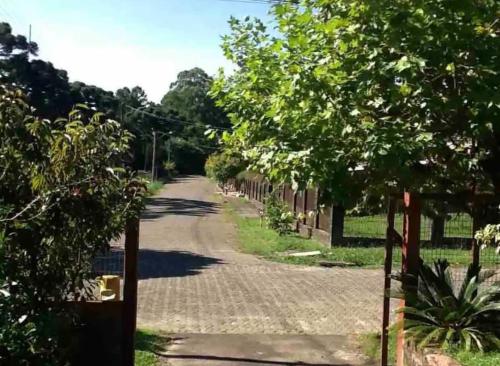 an empty street with a fence and trees at Hospedagem da Dona Carla in Canela