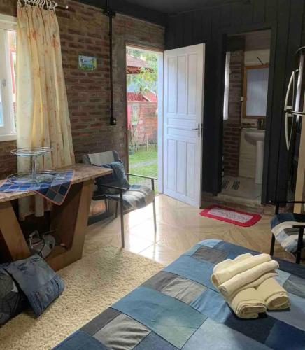 a living room with a bed and a bathroom at Hospedagem da Dona Carla in Canela