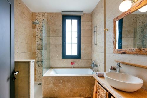 a bathroom with a tub and a sink at VillaSunset with Sea, Chios and Sunset View in Cesme