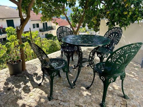 a table and four chairs sitting next to a tree at Casa Dionísio in Amarante