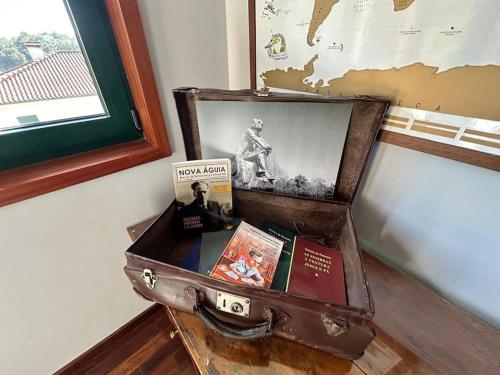 an old suitcase with books on top of a table at Casa Dionísio in Amarante