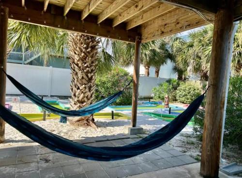 a hammock in a pavilion with a palm tree at The Back Nine in Pensacola Beach
