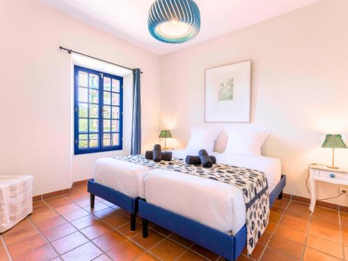 une chambre avec un lit et une fenêtre dans l'établissement Manoir de Duke - piscine, parc arboré, clim, parking gratuit, à Cannes