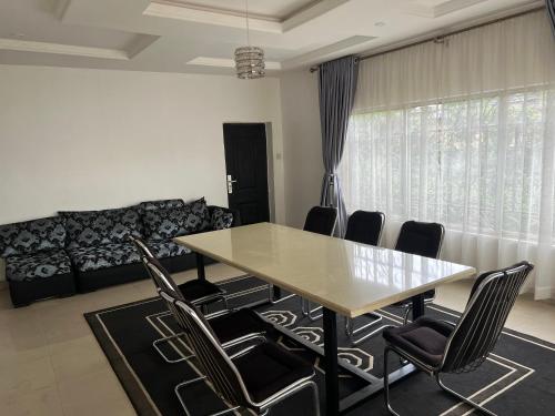 a dining room with a table and chairs at Apartment Three Oranges SH 75 E Nza Street Independence Layout Enugu in Mama