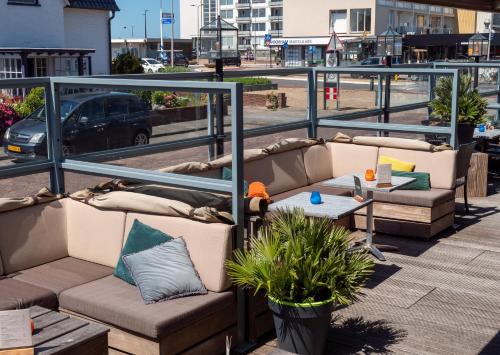 a group of couches on a balcony with a street at Heeren van Noortwyck in Noordwijk aan Zee