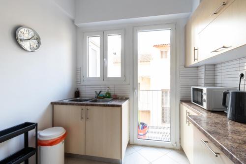 a kitchen with a sink and a large window at Syntagma sq, luxury & spacious apartment in Athens