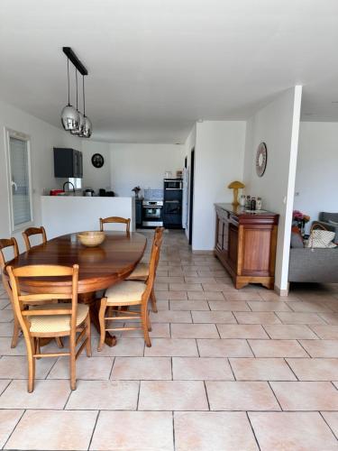 une cuisine et une salle à manger avec une table et des chaises en bois dans l'établissement Maison face au lac, à Lacanau