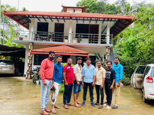 a group of men standing in front of a house at Vasu estate villa in Madikeri