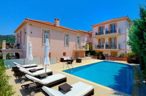 a villa with a swimming pool in front of a house at Korina Gallery Hotel in Vathi
