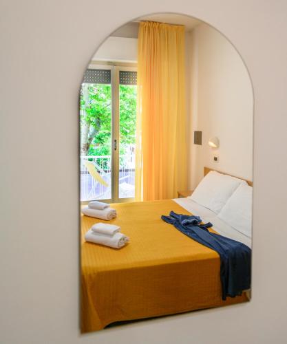 a bedroom with a bed with two towels on it at Hotel St. Moritz in Rimini