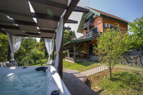 a hot tub on a deck in front of a house at Kuća za odmor Casa Huerta in Frketič