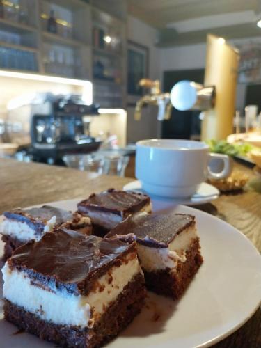 a plate of chocolate cake and a cup of coffee at Hotel Zelený potok in Pec pod Sněžkou