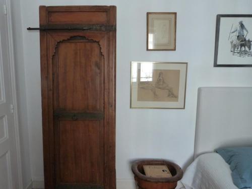 Cette chambre dispose d'une porte en bois à côté d'un lit. dans l'établissement Chambre d'hôtes La grotte de Voltaire, à Nantes