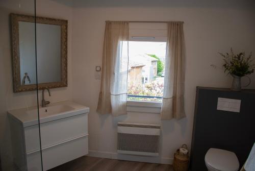 Un baño con lavabo y ventana. en Maison de la Porte des Loups dans le Ventoux, en Bédoin