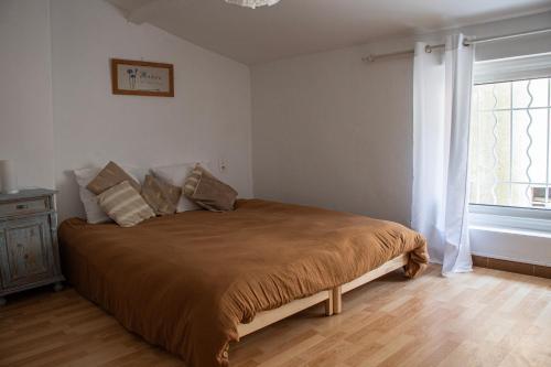Un dormitorio con una cama con una ventana grande. en Maison de la Porte des Loups dans le Ventoux, en Bédoin
