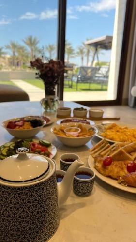 Una mesa con platos de comida sobre una mesa. en Hawana Salalah, en Salalah