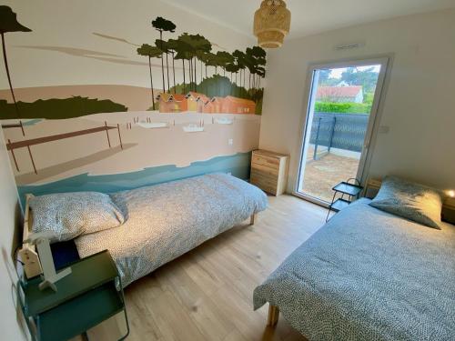 - une chambre avec 2 lits et une fresque murale dans l'établissement Lumineuse maison accès plage à pied à Plougasnou, à Plougasnou