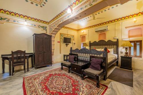 a bedroom with a bed and a desk and a piano at Hotel Shahi Palace Mandawa in Mandāwa