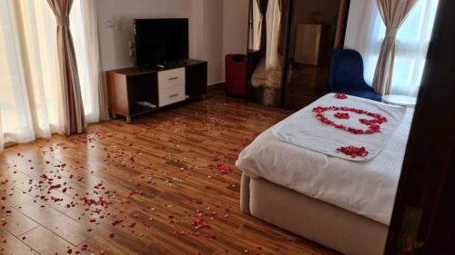 a bedroom with a bed with red flowers on the floor at Pyramids Sunshine View in Cairo