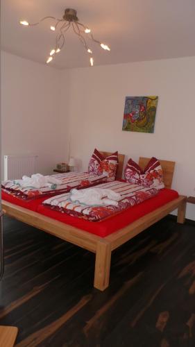 a large bed in a room with a red blanket at Ferienhaus an der Brunnenaue 4 Sterne, E-Ladestation am Haus, Wlan, Netflix, Garten in Sagard