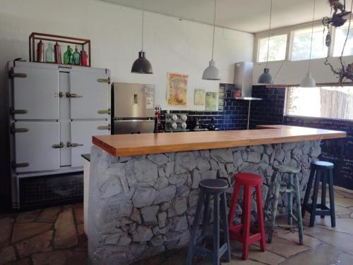 a kitchen with a stone counter and stools at Barracuda in Ciudad de la Costa
