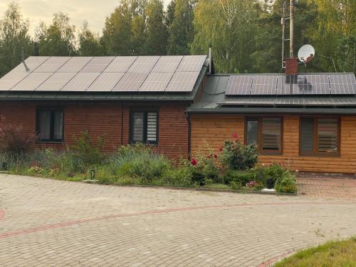 a house with solar panels on top of it at Leśna Polana- Kompleks Domków Mieszkalnych in Kamionka