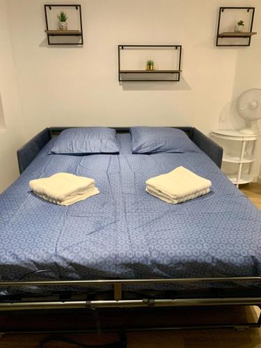 - un lit bleu avec 2 serviettes dans l'établissement Studio Cosy et Moderne, à Labruguière