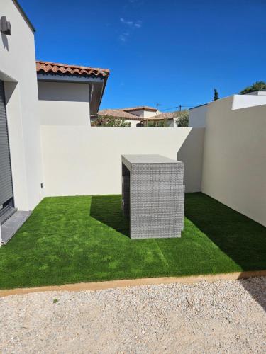 une maison blanche avec une pelouse verte dans l'établissement Studio meublé, à Marseillan