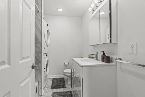 a white bathroom with a toilet and a sink at Beautiful 1BD With Balcony Hosted By StayRafa - 2F in Philadelphia