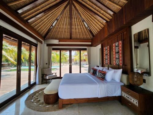 a bedroom with a large bed in a room with windows at KANDORA Luxury villas in Maujawa
