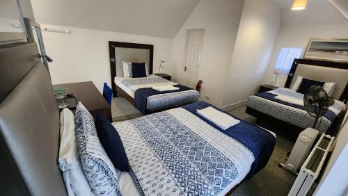 a room with three beds in a room at Gatwick Castle B&B in Horley