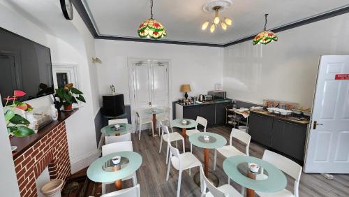 a room with tables and chairs and a kitchen at Gatwick Castle B&B in Horley