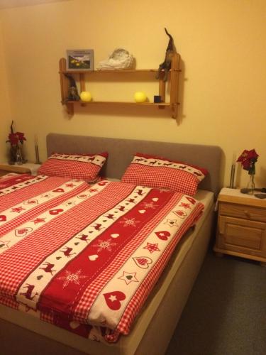 a bedroom with two beds with red and white blankets at Ferienwohnung Auszeit in Fischen