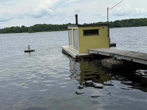 a small house on a dock on a body of water at Möckelsnäs Herrgård in Diö