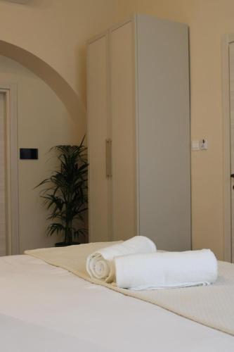 a bed with two towels on it with a mirror at North Lodge by PetitChic in Mellieħa