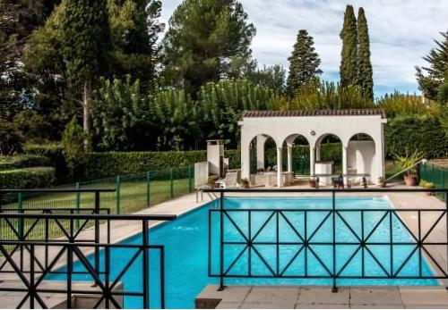 - une piscine avec un kiosque à côté d'un jardin dans l'établissement Manoir de Duke - piscine, parc arboré, clim, parking gratuit, à Cannes