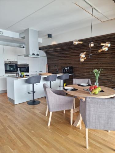 a kitchen and dining room with a wooden table and chairs at The Seaview Suite - Tromsø harbour! in Tromsø