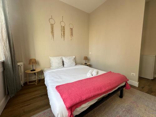 - une chambre avec un lit recouvert d'une couverture rose dans l'établissement Le Bourgeois, spacieux et central, à Limoges