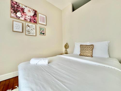 une chambre avec un grand lit avec des draps blancs dans l'établissement Le Bourgeois, spacieux et central, à Limoges