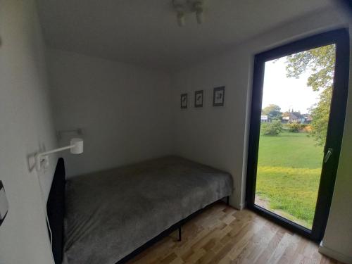 a room with a bed and a large window at Pod Gruszą in Sasino