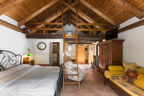 ein Schlafzimmer mit einem Bett und einem Sofa in einem Zimmer in der Unterkunft Fattoria l'Amorosa in Sementina