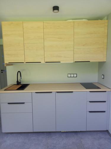 a kitchen with white counters and wooden cabinets at Pod Gruszą in Sasino