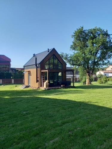 a house in a field with a tree at Pod Gruszą in Sasino