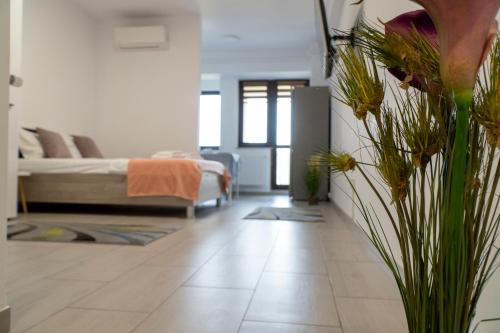a living room with a bed and a vase of flowers at Studio Accommodation City Center in Iaşi